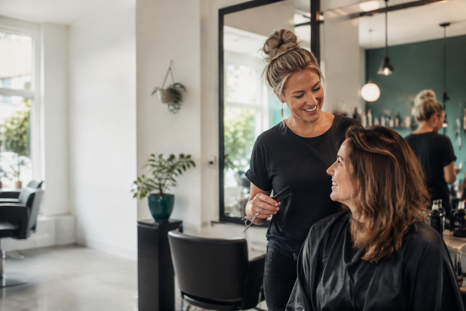 Kapper in gesprek met een klant in de salon